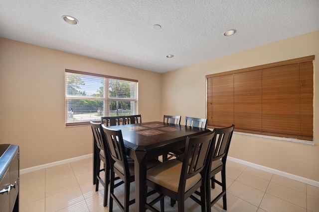 dining area featuring light tile patterned floors and a textured ceiling