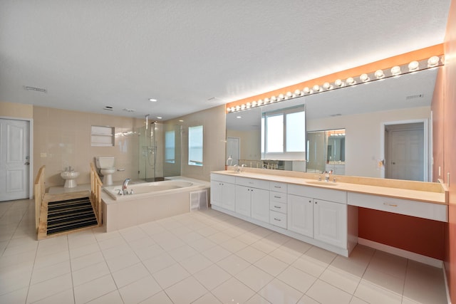 full bathroom with tile patterned flooring, vanity, a textured ceiling, and a bidet