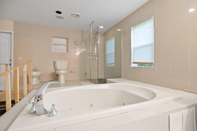 bathroom with a bidet, a textured ceiling, toilet, independent shower and bath, and tile walls