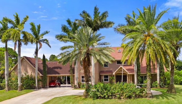 view of front of property featuring a front yard and a carport