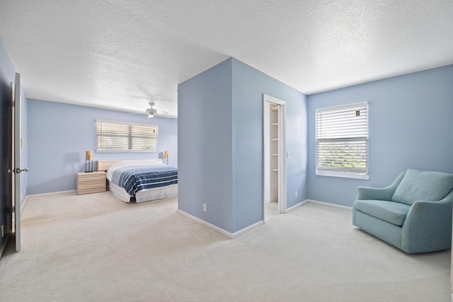 carpeted bedroom featuring a walk in closet, a closet, and a textured ceiling