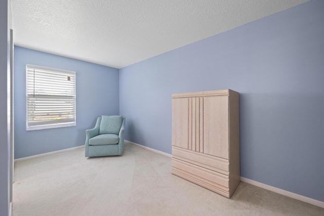 living area with a textured ceiling and light colored carpet