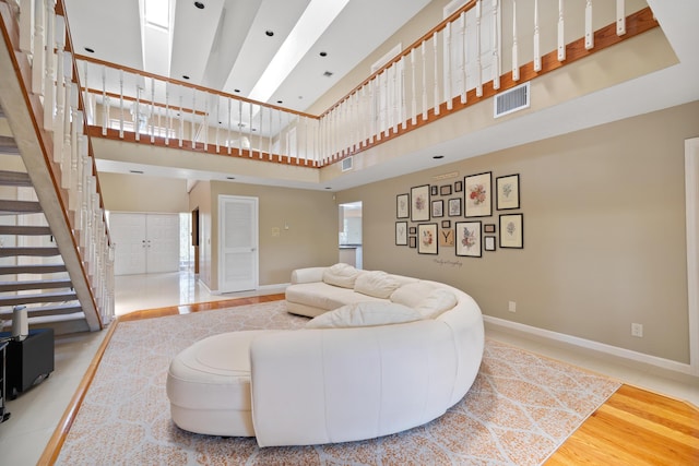 living room with wood-type flooring and a towering ceiling