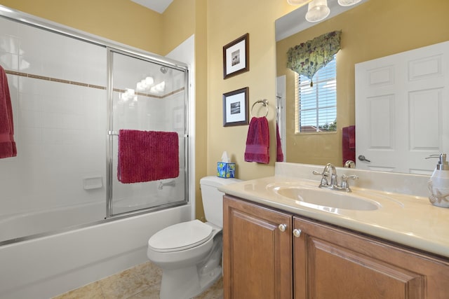 full bathroom featuring shower / bath combination with glass door, tile patterned flooring, vanity, and toilet