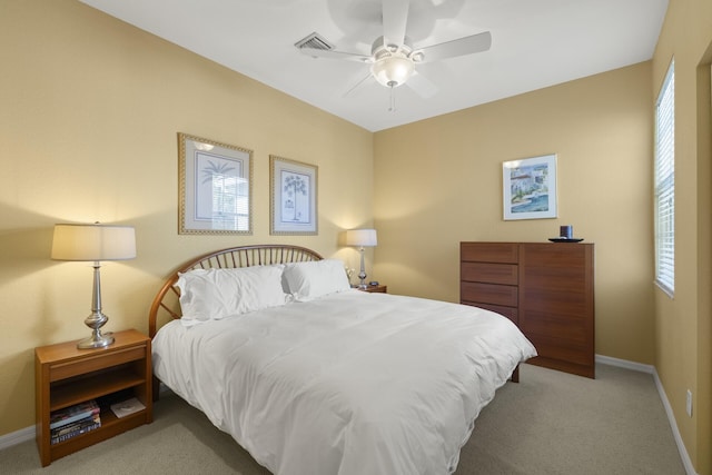 carpeted bedroom featuring multiple windows and ceiling fan