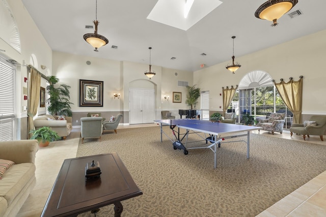 game room with a skylight and a towering ceiling