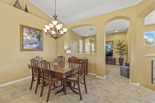 dining room featuring a notable chandelier, light tile patterned flooring, and lofted ceiling