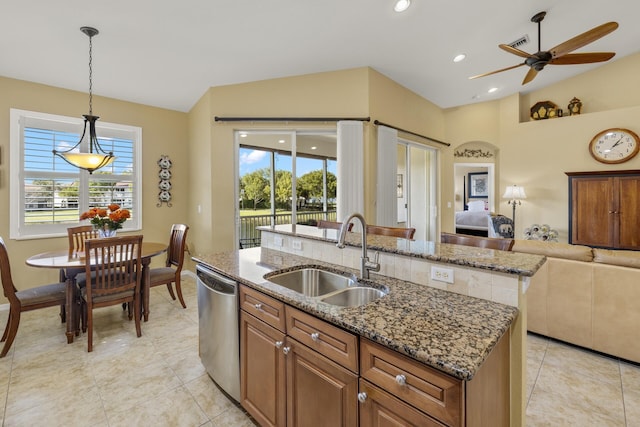 kitchen with dishwasher, a kitchen island with sink, sink, ceiling fan, and decorative light fixtures