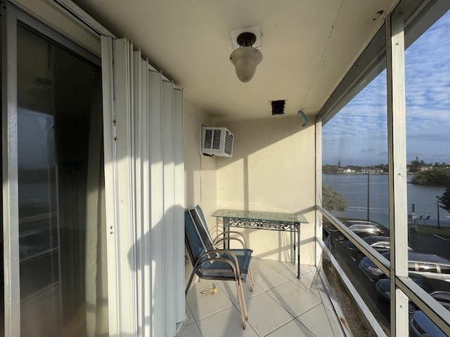 balcony featuring a wall mounted AC and a water view