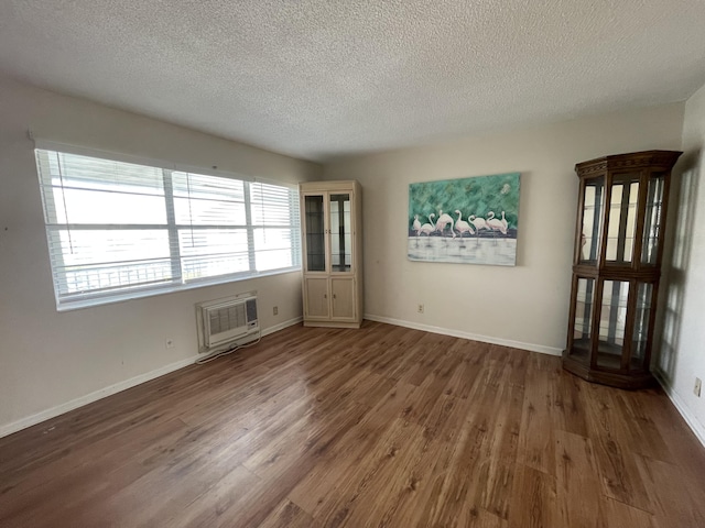 spare room featuring dark hardwood / wood-style flooring and a textured ceiling