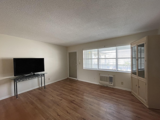 unfurnished living room with heating unit, a textured ceiling, and hardwood / wood-style floors