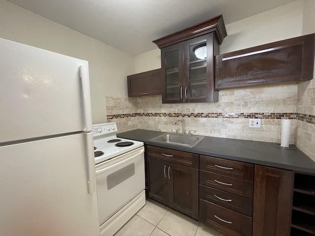 kitchen featuring white appliances, dark brown cabinetry, tasteful backsplash, sink, and light tile patterned floors