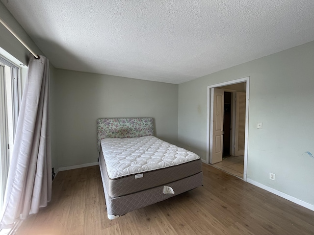 bedroom with a textured ceiling and hardwood / wood-style floors