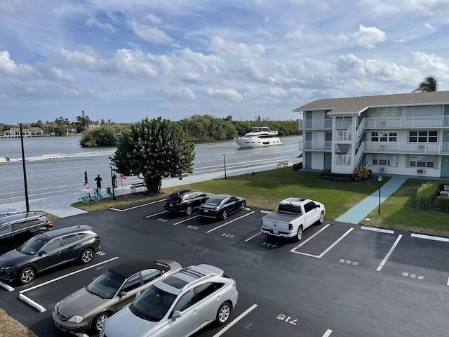 view of car parking with a water view