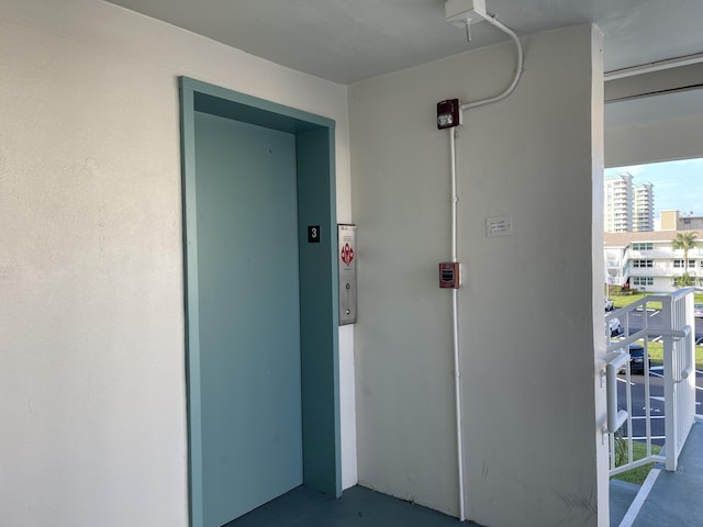 hall featuring elevator and concrete flooring