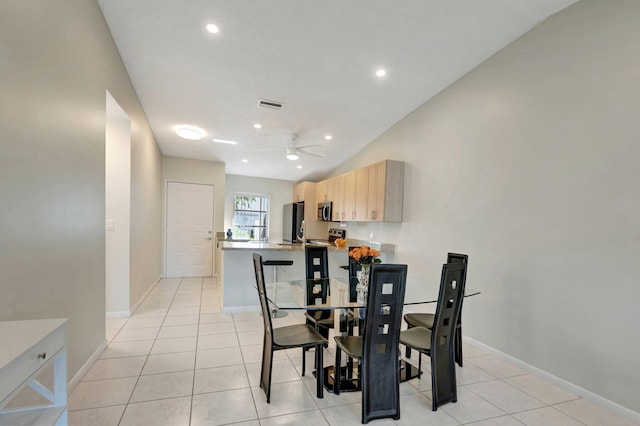 tiled dining room with ceiling fan and lofted ceiling