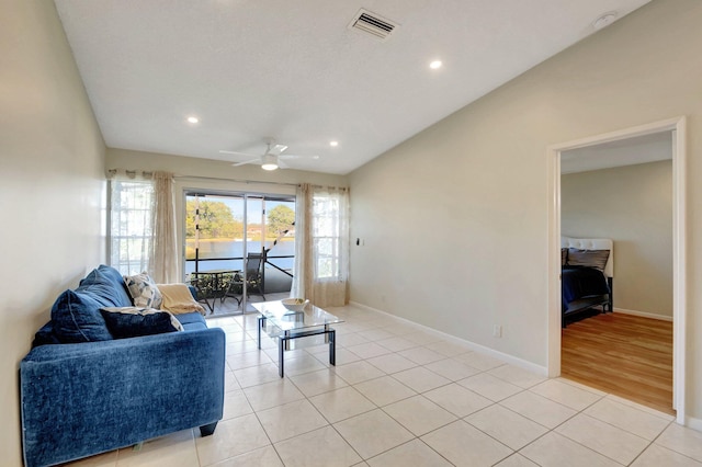 tiled living room featuring ceiling fan and lofted ceiling