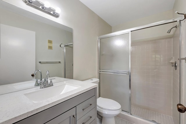 bathroom with vanity, toilet, and a shower with shower door