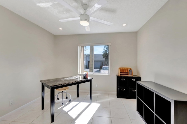 home office featuring ceiling fan, light tile patterned floors, and a textured ceiling