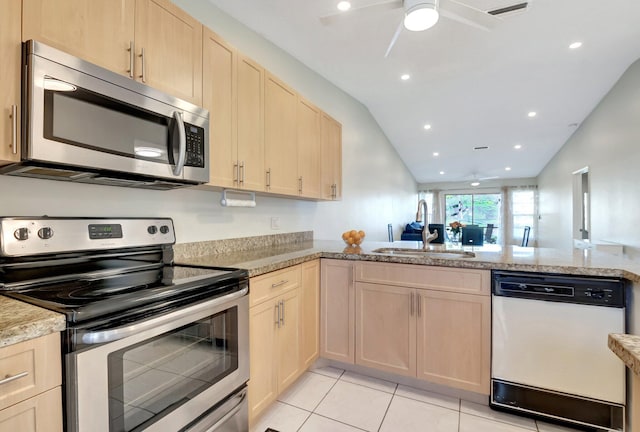 kitchen featuring light brown cabinets, sink, lofted ceiling, and stainless steel appliances