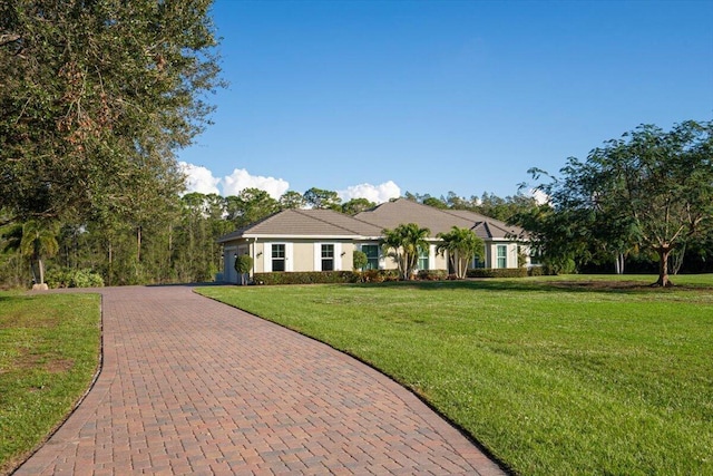 view of front of home with a tile roof, a front lawn, and decorative driveway