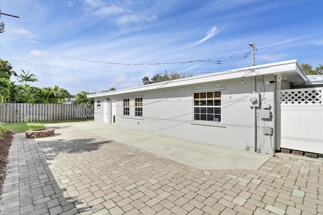 back of house featuring an outdoor fire pit and a patio area