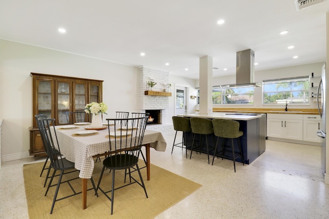 dining space with sink and a fireplace