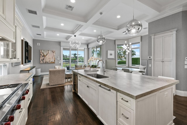 kitchen featuring coffered ceiling, sink, a center island with sink, beam ceiling, and white cabinets