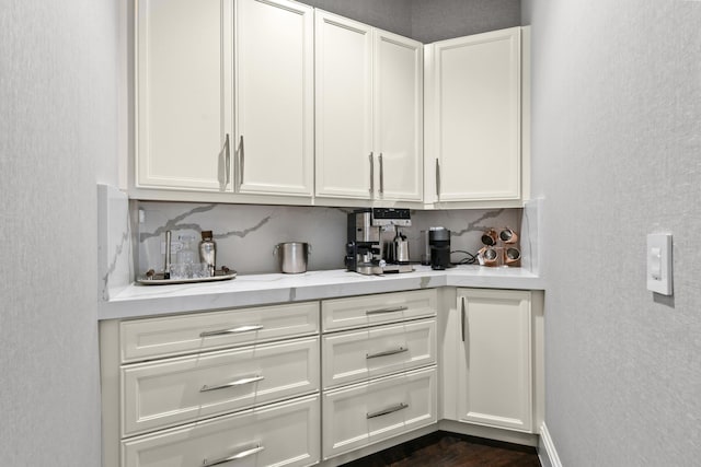 bar featuring decorative backsplash and white cabinets