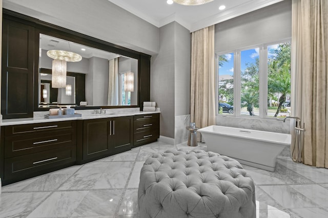 bathroom featuring a notable chandelier, crown molding, a bathing tub, and vanity