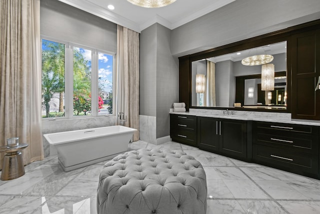 bathroom with vanity, a chandelier, a washtub, and crown molding