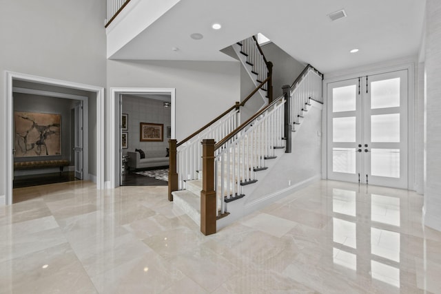 foyer with french doors and a high ceiling