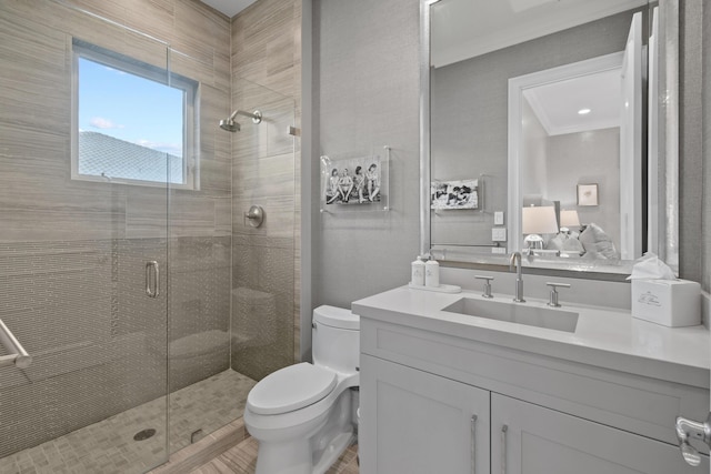 bathroom with vanity, ornamental molding, toilet, and walk in shower