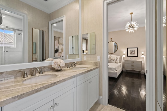 bathroom featuring vanity, hardwood / wood-style flooring, ornamental molding, and an inviting chandelier