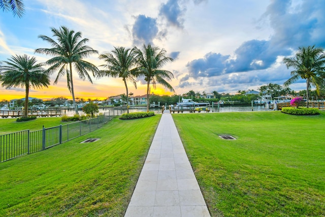 surrounding community with a lawn and a water view