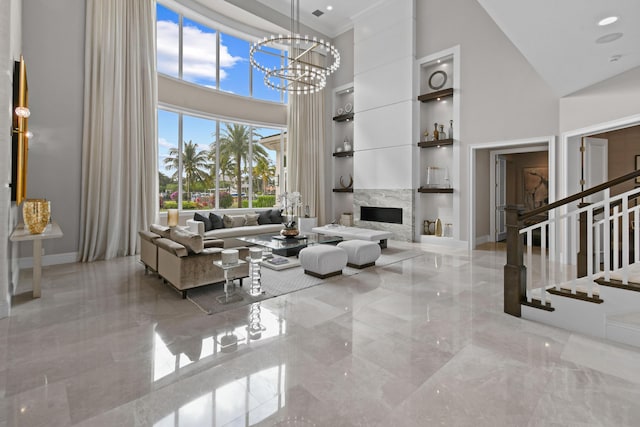 living room featuring a high ceiling, a notable chandelier, and built in shelves