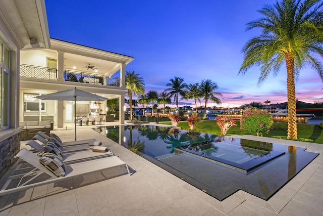 pool at dusk featuring a patio area