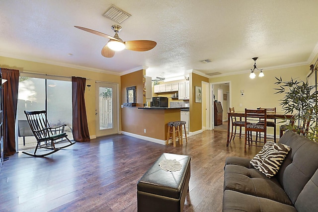 living room featuring dark hardwood / wood-style floors, ceiling fan, crown molding, and a textured ceiling