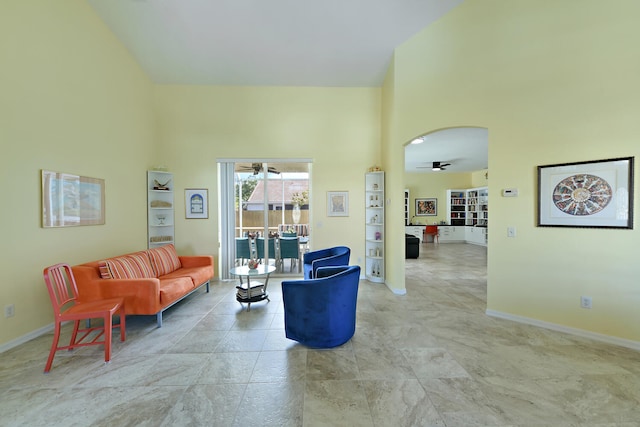 living room with ceiling fan and a high ceiling