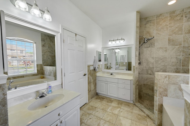 bathroom featuring tile patterned floors, vanity, separate shower and tub, and tile walls