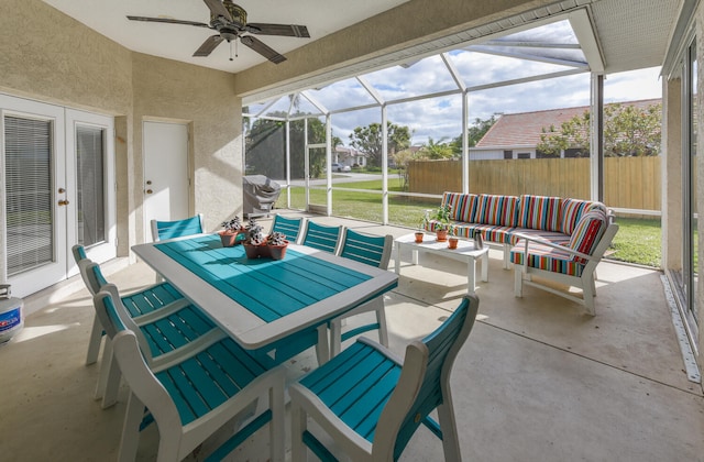 view of patio / terrace with an outdoor living space, glass enclosure, and ceiling fan