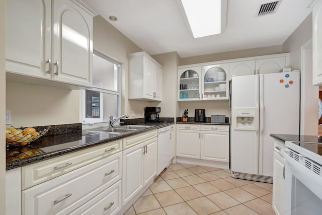 kitchen featuring white appliances, sink, light tile patterned floors, and white cabinetry