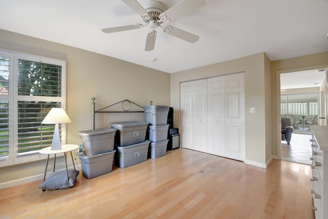 bedroom with ceiling fan, light wood-type flooring, and a closet