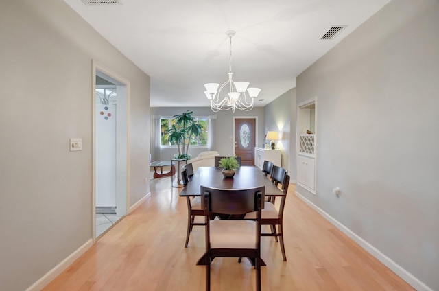 dining space featuring a chandelier and light hardwood / wood-style flooring