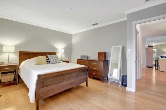 bedroom with crown molding and light hardwood / wood-style flooring