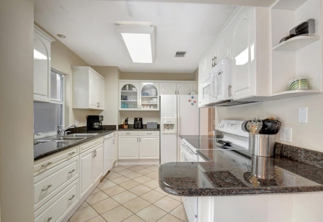 kitchen with sink, white appliances, white cabinets, and kitchen peninsula