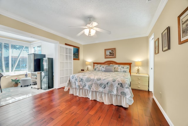 bedroom featuring ceiling fan, crown molding, light hardwood / wood-style floors, and a textured ceiling