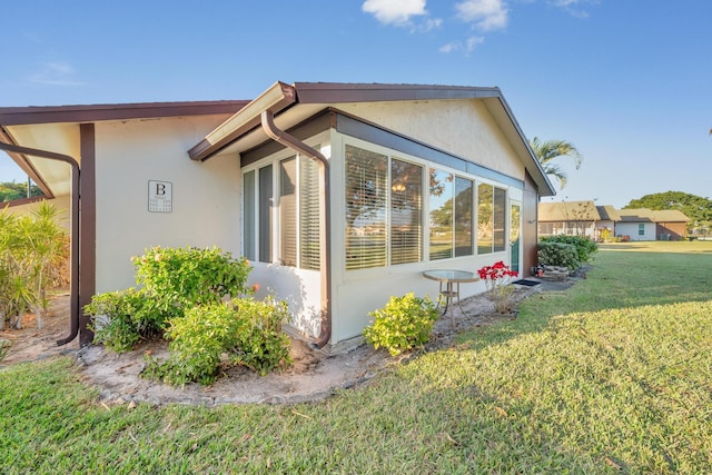 view of side of home with a lawn