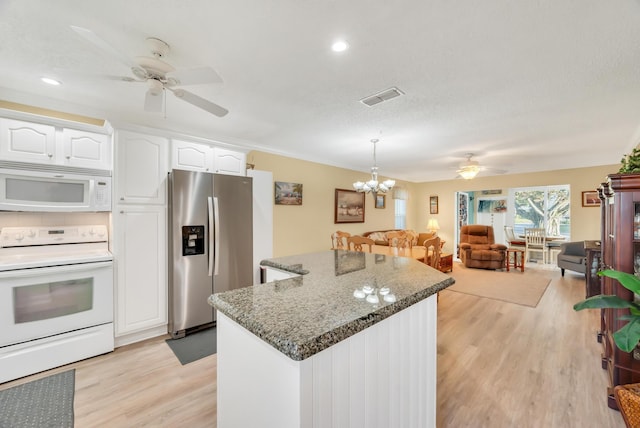 kitchen with a center island, hanging light fixtures, white appliances, white cabinets, and ceiling fan with notable chandelier