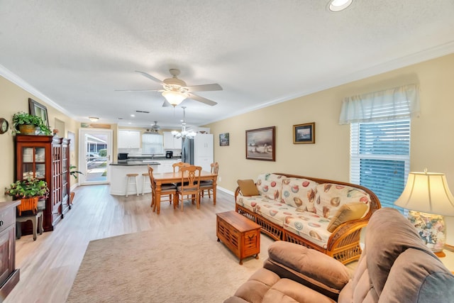 living room with a textured ceiling, ceiling fan, crown molding, and light hardwood / wood-style flooring